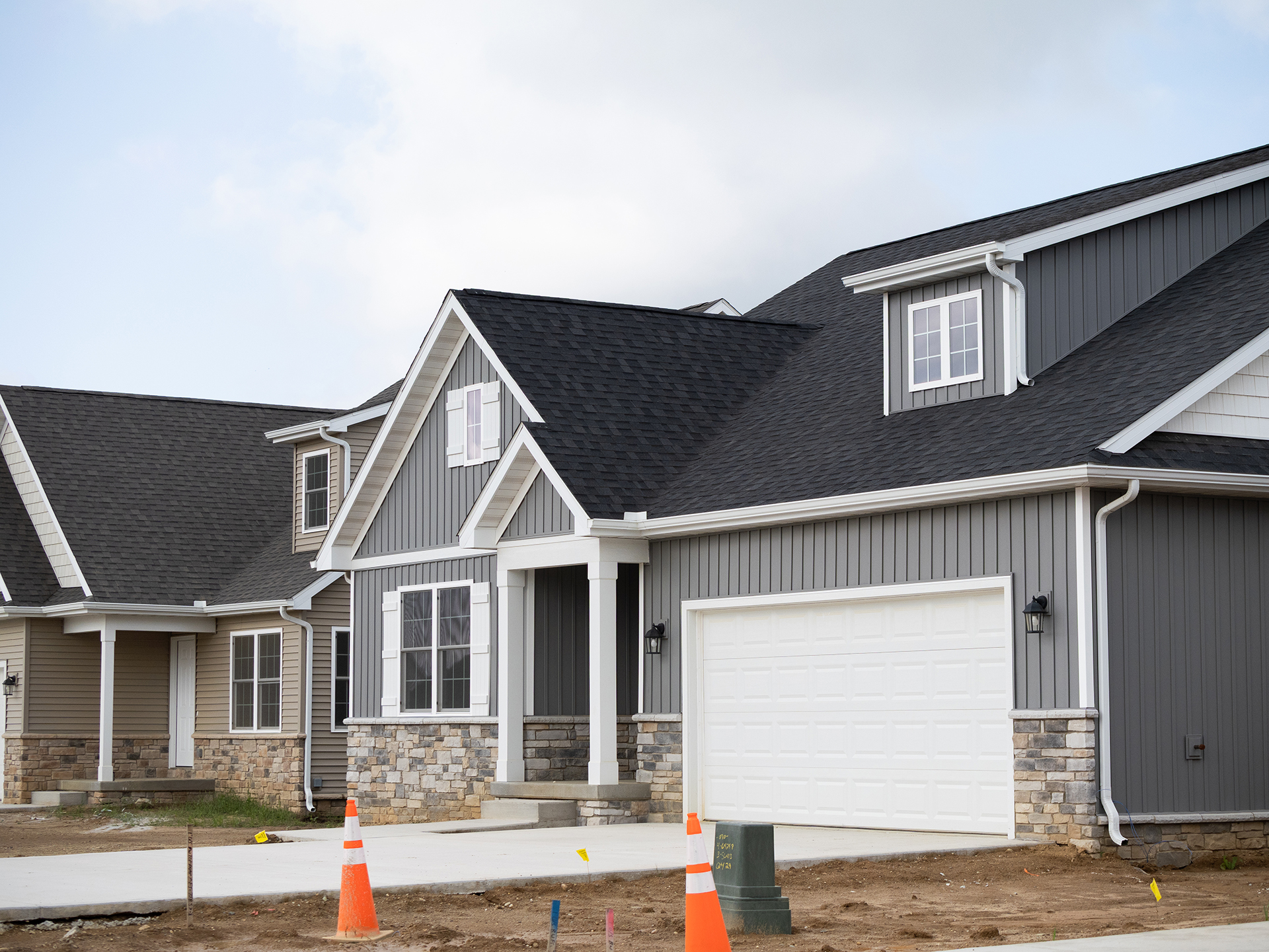 new home with dark grey siding and stone details