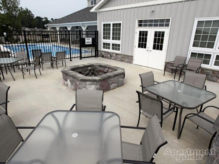 outdoor community area with stone firepit and pool