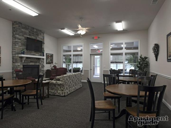 community room with tables, chairs, and fireplace